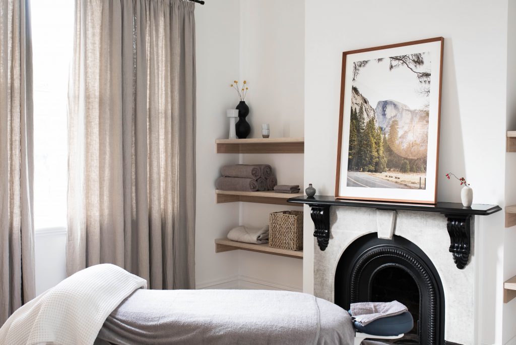 Milk & Honey Remedial Massage Melbourne. Treatment room 1. Milk & Honey Treatment room 1. Massage bed and fireplace.